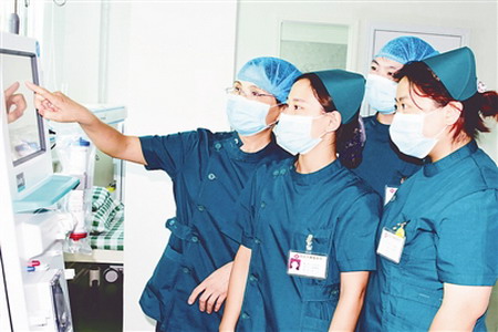 蔡惠英（左一）与同事交流血透设备使用经验