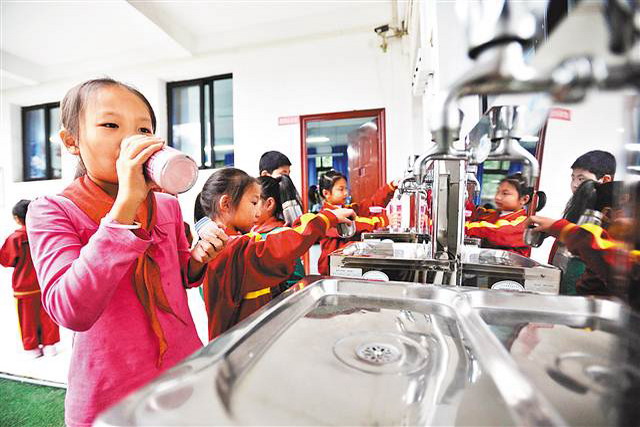 南岸区中窑小学，学生们正在直饮水机前接水喝。