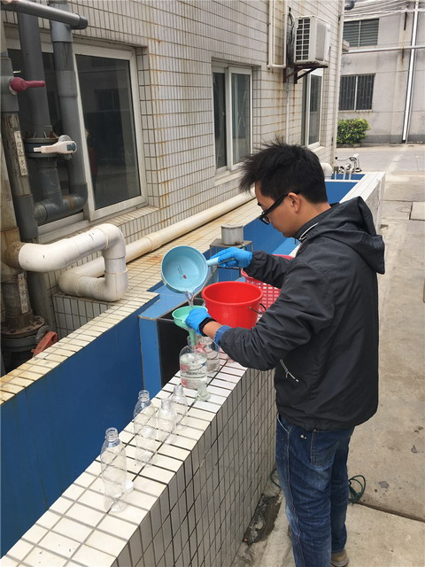 联合执法组对企业的综合废水站进行检查，采取水样分析。（江门市环保局供图）
