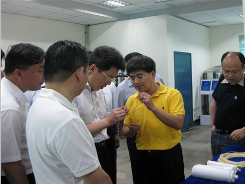 洪耀良教授正在请张家港市委副书记梁一波体验超滤膜膜丝的强度